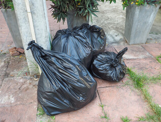 Black garbage bags big and small Completely sealed, 4 bags are placed on the cement floor.