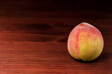 Ripe whole peach fruit isolated on wood background