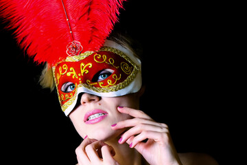 Red carnival mask with lush feathers. Blond woman