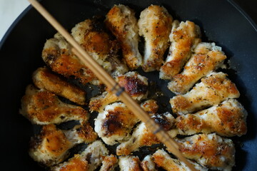 Fried chicken wings. Golden color. In a pan.
