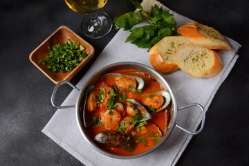 French seafood bouillabaisse soup/fish stew with mussels served with garlic toast baguette
