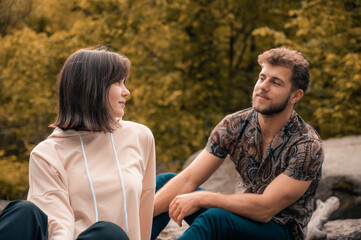 Lovely young couple walking in park, spending time together. Loving ogle look on each other. Travel...