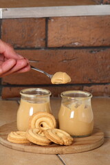 Eating milk pudding dessert in jar and cookies