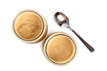 Milk pudding dessert in jars with spoon. Isolated with clipping