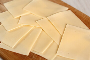 Cheese slices on wooden cutting board