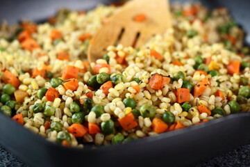 Cooking pearl barley with carrot and green peas