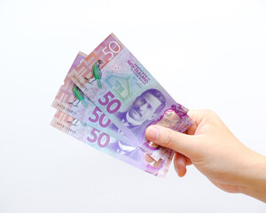 Closeup Dollar banknotes in male hand on a solid background, 50 NZ bills from New Zealand, held by a male hand on isolated white background, payday concept
