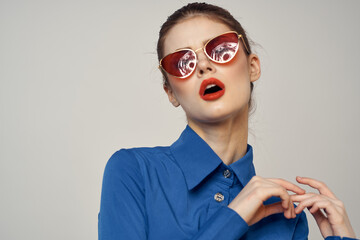 Portrait of a woman in sunglasses and a blue shirt on a light background cropped view of Model Copy Space