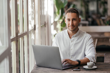 young man working on his computer at the cafe. business, freelance