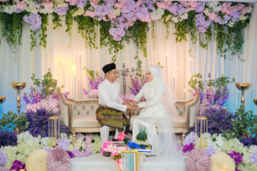 The groom put the wedding bracelet to the bride during solemnization ceremony. Family and happiness...