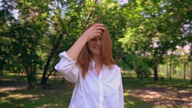camera move around adult joyful redhead woman in white shirt happy lifestyle in summer season outdoors