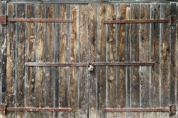 Old wooden gate with padlock. Close up.