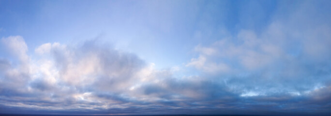 Panorama, sunrise in the sky covered with clouds.