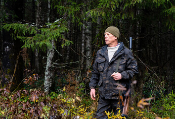 Hunter with a gun in a forest road	