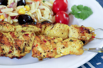 brochettes de poulet grillé et salade de pâtes dans une assiette