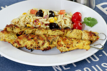 brochettes de poulet grillé et salade de pâtes dans une assiette