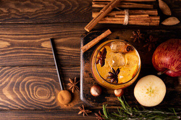homemade apple cider with apple pieces, cinnamon and spices in a glass