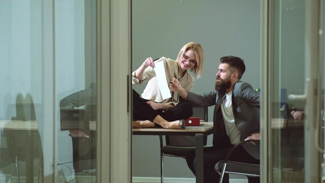 Sensual secretary and employee. Sexy female office worker flirting with employee in workplace. Sexual harassment and office abuse concept. Young boss seduces female employee.