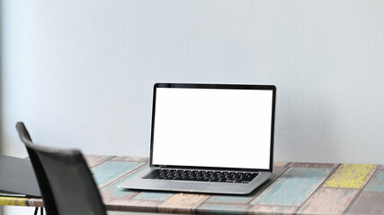 Contemporary workspace with with screen laptop computer on wooden table.