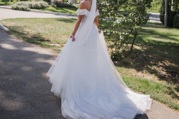Fototapeta na wymiar bride in wedding dress and bouquet in the park