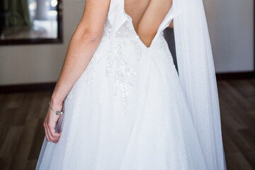 Fototapeta na wymiar back of the bride in wedding dress in the morning