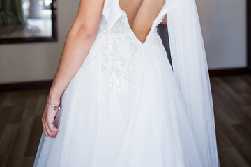 Naklejka premium back of the bride in wedding dress in the morning