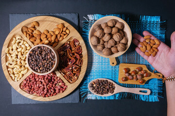 Nuts in a wooden plate. Pecans, almonds, cashews, peanuts, walnuts, pine nuts. flat lay