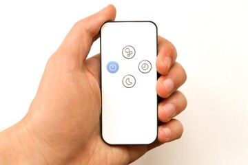 Remote control for controlling the air humidifier in the hand.  Remote control in hand on isolated white background