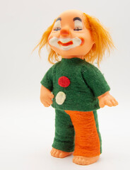 An old toy in a bright suit on a white background.