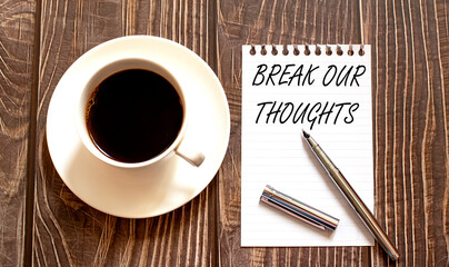 BREAK OUR THOUGHTS - white paper with pen and coffee on wooden background.