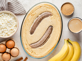Banana baked pudding. Cottage cheese (or ricotta) and banana pie (casserole) with cinnamon, eggs and brown sugar. Healthy morning breakfast or snack. Protein food. Top view. White table background.