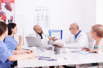 Obraz premium Healthcare specialist talking in conference room during medicine seminar. Clinic expert therapist discussing with colleagues about disease, medicine professional