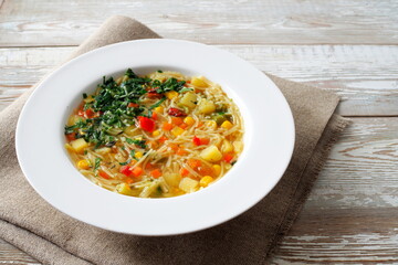 Vegetarian vegatable soup with noodles on rustic wooden table. Healthy diet food.