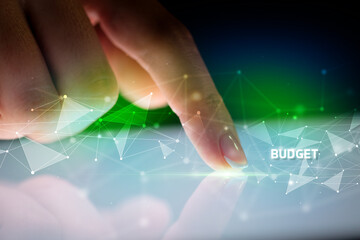 Finger touching tablet with BUDGET inscription, business concept