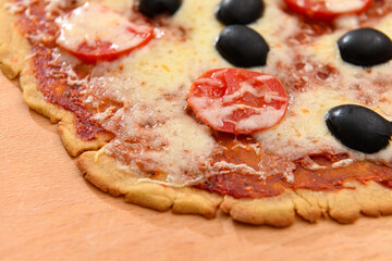 homemade pizza, vegetarian food, baked vegetables and cheese, tomatoes and olives, delicious food on a wooden background