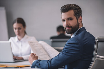 Man looking back and woman behind laptop