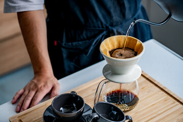 Fototapeta na wymiar Man making coffee in the kitchen. Delicious coffee image.