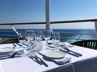 Formal and elegant table setting on outdoor al fresco terrace or patio restaurant onboard luxury...