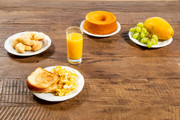 Breakfast, with plate of toast and eggs. White dish with grapes and papaya, orange juice and cheese. Top view and space for text.