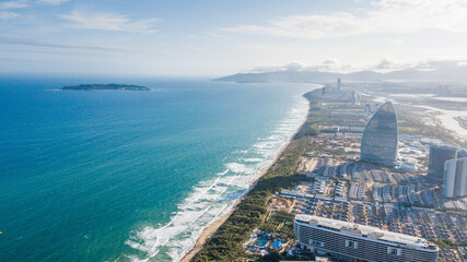 Aerial view of Haitang Bay, Sanya, Hainan, China. Top View of luxury beach with palm trees against the background of the beauty of the sea with coral reefs.Travel beach holiday background concept