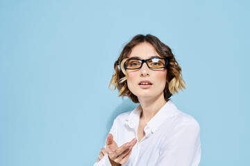 Business woman on a blue background glasses with dark rims curly hair Light shirt cropped view