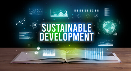 SUSTAINABLE DEVELOPMENT inscription coming out from an open book, creative business concept