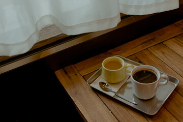 Hot coffee and tea on wooden table in cafe.