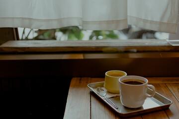 Hot coffee and tea on wooden table in cafe.