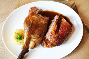 Ente gegrillt frisch aus dem Ofen zu Weihnachten mit Bier Knödel und Blaukraut auf einem Holztisch