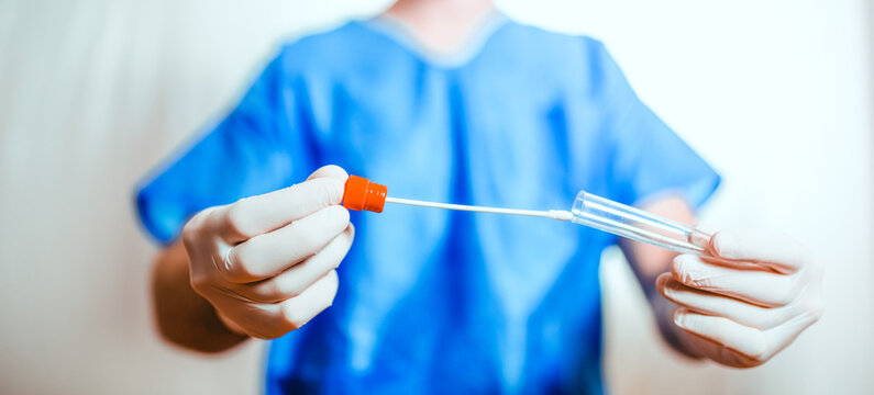 Medico o infermiere fa il test del tampone salivare nella provetta