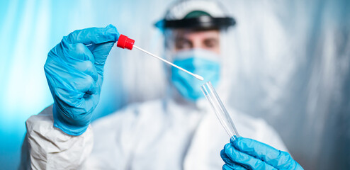 Medico o infermiere con tuta bianca covid fa il test del tampone salivare per il coronavirus covid...