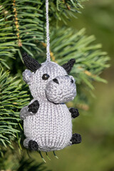 Knitted toy little bull on a Christmas tree, a symbol of 2021