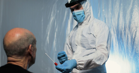 Infermiere fa il test tampone covid a paziente seduto di spalle