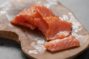 Smoked salted salmon slices on wood board
